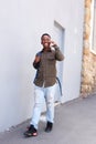 Smiling black male student walking and talking on mobile phone Royalty Free Stock Photo