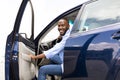 Smiling black man driving new car in the city Royalty Free Stock Photo