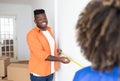 Smiling Black Man Holding Tape Ruler, Helping Wife Measuring Wall At Home Royalty Free Stock Photo