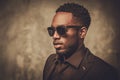 Smiling black man with sunglasses posing on dark background. Royalty Free Stock Photo