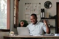 Smiling black man using laptop at home in living room. Happy mature businessman send email and working at home. African Royalty Free Stock Photo