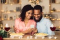 Smiling black man and woman using smartphone during dinner Royalty Free Stock Photo