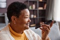 Smiling black senior woman recording voice message via smartphone Royalty Free Stock Photo