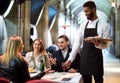 Black waiter serving table on the terrace Royalty Free Stock Photo