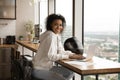 Smiling black woman biker sit by laptop in stylish apartment