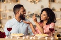 Smiling black woman feeding her man on a date Royalty Free Stock Photo