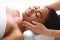 Smiling black woman having lifting face massage at spa Royalty Free Stock Photo