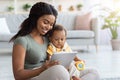 Black Woman And Her Adorable Infant Son Using Digital Tablet At Home Royalty Free Stock Photo