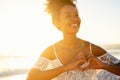 African beautiful girl making hand heart at beach during sunset Royalty Free Stock Photo