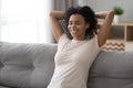 Smiling black woman relax on couch at home Royalty Free Stock Photo