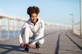 Smiling Black Woman Tying Laces On Her Sneakers Before Jogging Outdoors Royalty Free Stock Photo