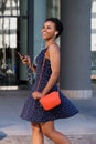 Smiling black woman walking and listening to music on earphones Royalty Free Stock Photo