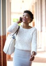 Smiling black woman walking and talking with cell phone Royalty Free Stock Photo