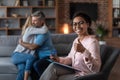 Smiling black young doctor in glasses show thumb up approves therapy of mature european couple Royalty Free Stock Photo