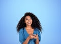 Smiling black young woman with phone on empty blue background. Copy space Royalty Free Stock Photo