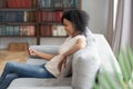 Smiling black young woman relax at home using cellphone Royalty Free Stock Photo