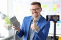 Smiling blogger businessman holds a calculator and records training videos about earnings