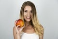 Smiling blond attractive woman holding juicy apple in one hand isolated white background