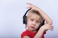 Smiling blond boy in headphones listen the music and dance. Home studying Royalty Free Stock Photo