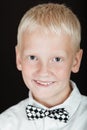 Smiling blond boy wearing checkered bow tie Royalty Free Stock Photo