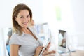 Smiling blond businesswoman using tablet at office