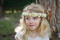 Smiling blond girl with big blue eyes and with daisies on head Royalty Free Stock Photo