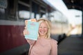 Smiling woman on the the bus station holding a books