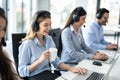 Smiling blond haired woman operator with headset drinking morning coffee and starting doing her online job at customer support Royalty Free Stock Photo