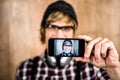 Smiling blond hipster taking selfie