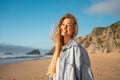 Smiling blond woman enjoying breeze on sandy ocean beach Royalty Free Stock Photo