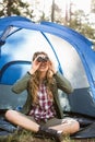 Smiling blonde camper looking through binoculars Royalty Free Stock Photo