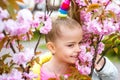 Smiling blonde girl standing in a blooming garden. Blooming cherry. Portrait of beautiful little girl. Close up of Royalty Free Stock Photo