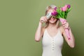 Smiling blonde girl with tulips and cash