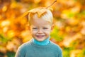 Smiling blonde kid hold autumn leafs in the nature. Autumn kid, cute child with fallen leaves in autumn park. Yellow Royalty Free Stock Photo