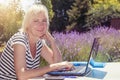 Smiling blonde middle aged woman outdoors
