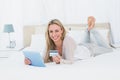 Smiling blonde shopping on line with tablet