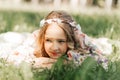 Smiling blonde teen girl posing in summer garden. Wearing flower wreath outdoors Royalty Free Stock Photo