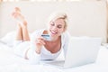 Smiling blonde woman doing online shopping Royalty Free Stock Photo