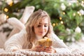 Smiling blonde woman with golden christmas gift box near christmas tree Royalty Free Stock Photo