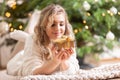 Smiling blonde woman with golden christmas gift box near christmas tree Royalty Free Stock Photo