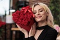 Smiling blonde woman holding red roses close up Royalty Free Stock Photo