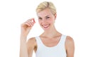 Smiling blonde woman looking at red pill Royalty Free Stock Photo