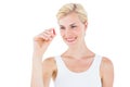 Smiling blonde woman looking at red pill Royalty Free Stock Photo