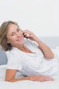 Smiling blonde woman lying on bed making a phone call Royalty Free Stock Photo