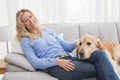 Smiling blonde woman petting her golden retriever Royalty Free Stock Photo