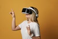 Smiling blonde woman explores virtual augmented reality wearing vr glasses, operates in virtuality. Woman in cyber space