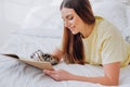 Woman writes in paper notebook with bionic arm lying on bed Royalty Free Stock Photo