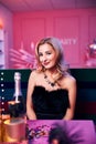 Smiling blonde young woman sitting at the festive table Royalty Free Stock Photo