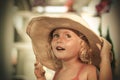 Smiling blue eyed blond little girl keeping her big hat Royalty Free Stock Photo