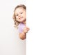 Smiling blue eyed little girl peeking behind a white board